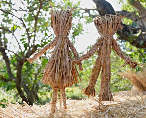 Male And Female Dolls Made From Straw In Garden