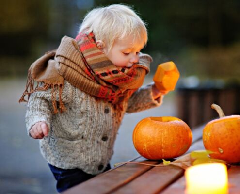 Toddler Playing With Halloween Pumpkins