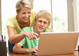 Mother Helping Her Teenage Son On The Laptop