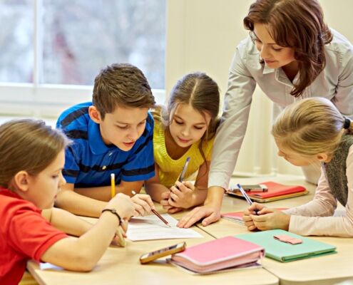 Group Of School Kids Writing Test In Classroom